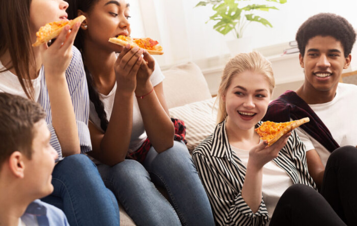Favorite fast food. Teens eating delicious pizza and chatting during home party